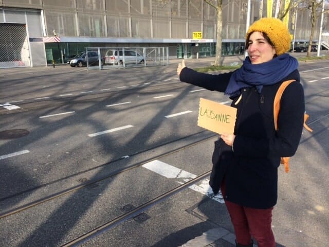 Mit Schild Autostopp machen.