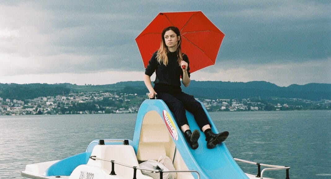 Lara Stoll mit Regenschirm auf einem Pedalo