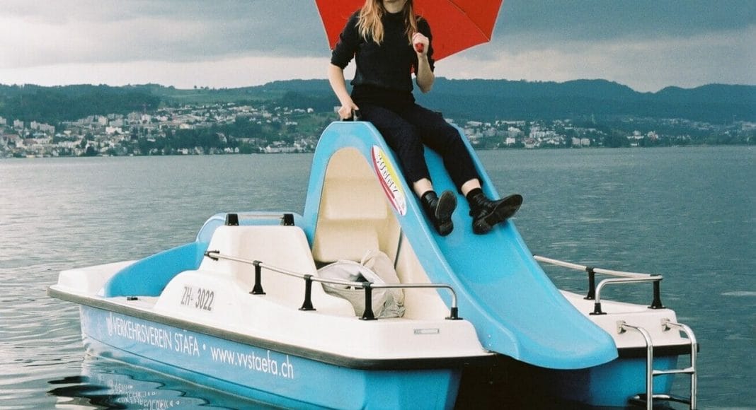 Lara Stoll mit Regenschirm auf einem Pedalo