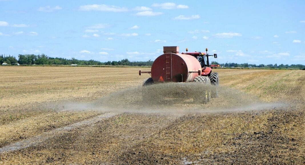 Traktor auf Feld beim Ausbringen von Gülle