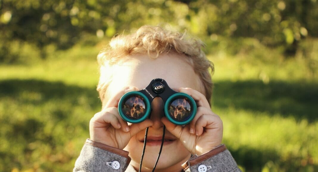 Ein kleiner Junge mit Feldstecher