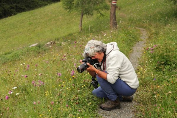 Christine Dobler Gross macht ein Foto in der Blumenwiese.